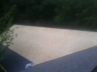 New OSB roof sheathing installed beside an existing shingle roof in Creighton